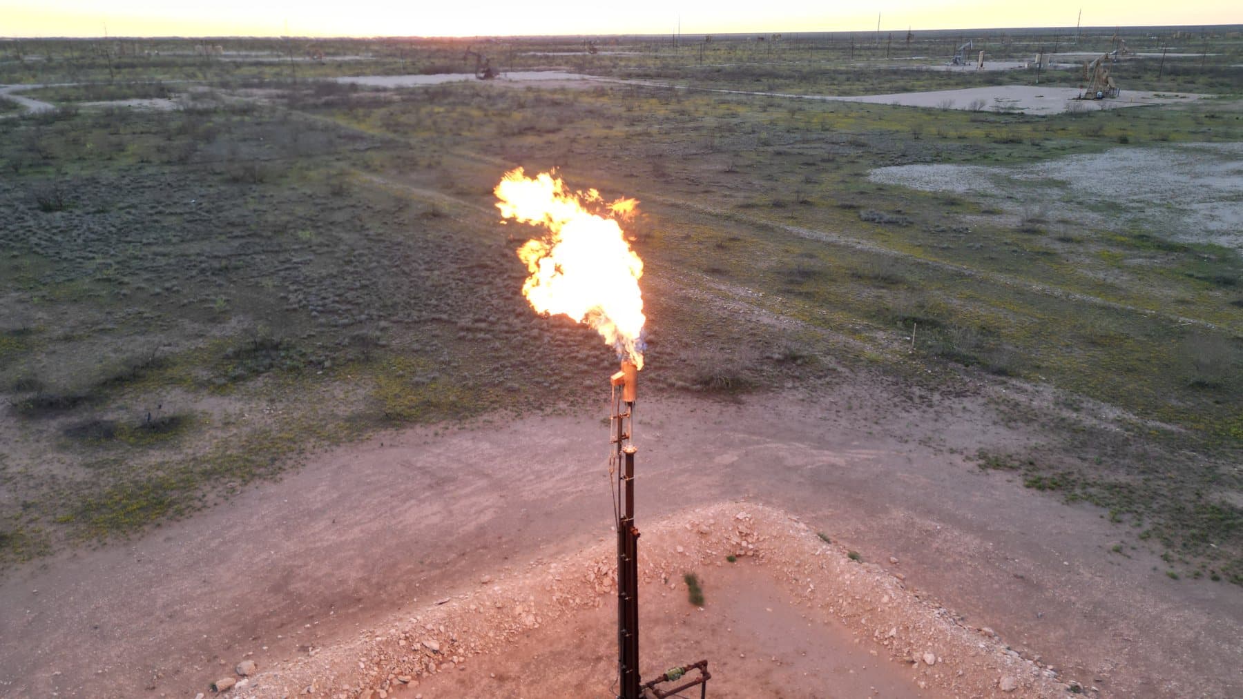 Full-load flame from a smokeless flare tip against a blue sky